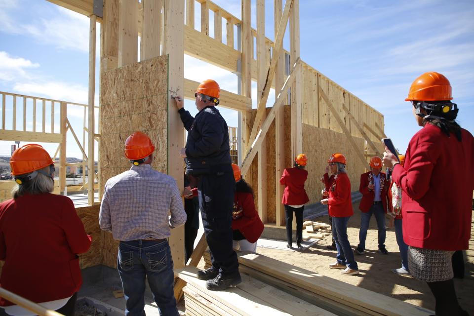 Community members line up to sign a door frame at the new under-construction Whataburger location on East Main Street in Farmington during a ceremony on Tuesday, March 12.