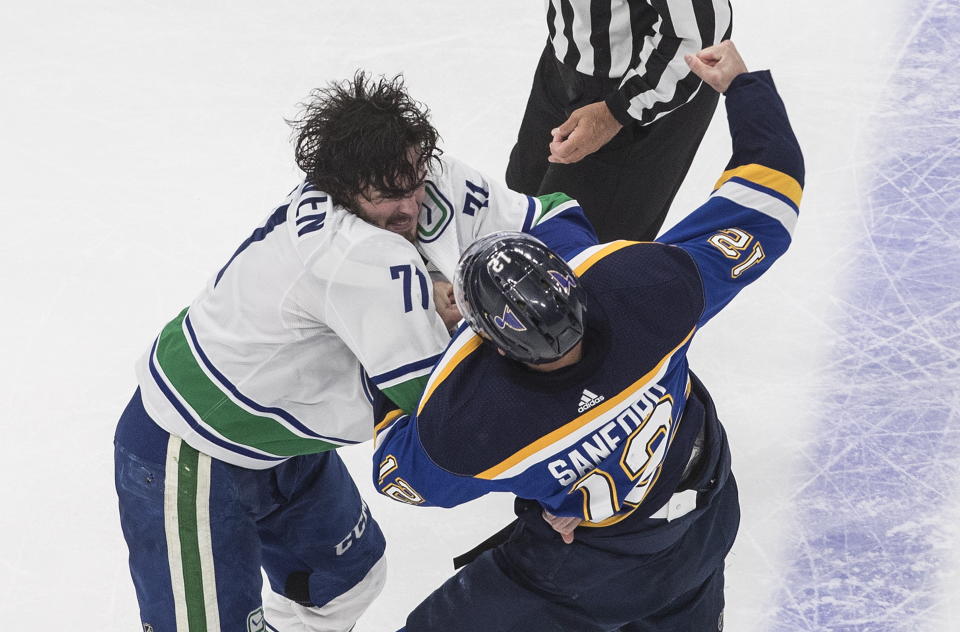 Vancouver Canucks' Zack MacEwen (71) and St. Louis Blues' Zach Sanford (12) fight during the second period of an NHL hockey Stanley Cup first-round playoff series, Friday, Aug. 14, 2020, in Edmonton, Alberta. (Jason Franson/The Canadian Press via AP)