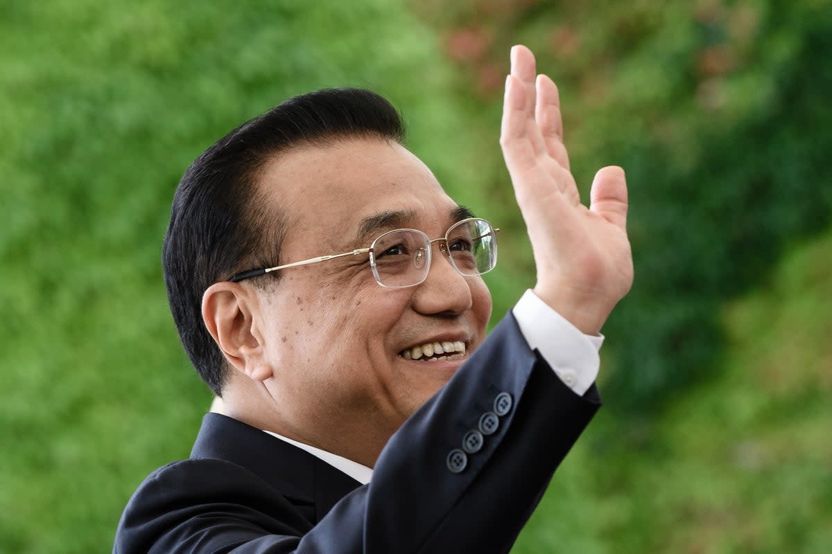 Li Keqiang waves during a military reception with German Chancellor Angela Merkel in 2018 (EPA)