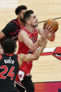 Chicago Bulls guard Tomas Satoransky, right, drives to the basket past Toronto Raptors guard Jalen Harris and center Khem Birch (24) during the first half of an NBA basketball game in Chicago, Thursday, May 13, 2021. (AP Photo/Nam Y. Huh)