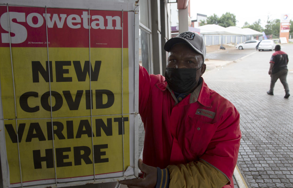 A man stands next to a newspaper headline.