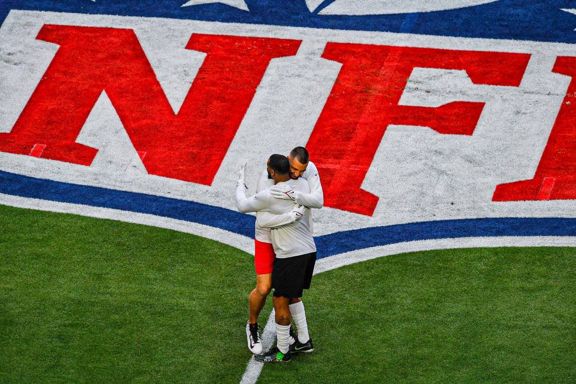 Kansas City Chiefs tight end Travis Kelce hugs an unidentified Philadelphia Eagles player on the field before the start of Super Bowl LVII Sunday, Feb. 12, 2023, in Glendale, Ariz.