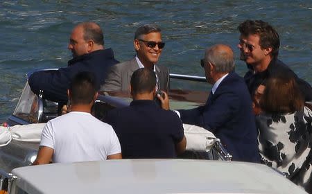 U.S. Hollywood star George Clooney (2nd L) smiles as he stands in a boat upon arriving at Venice September 26, 2014. REUTERS/Stefano Rellandini