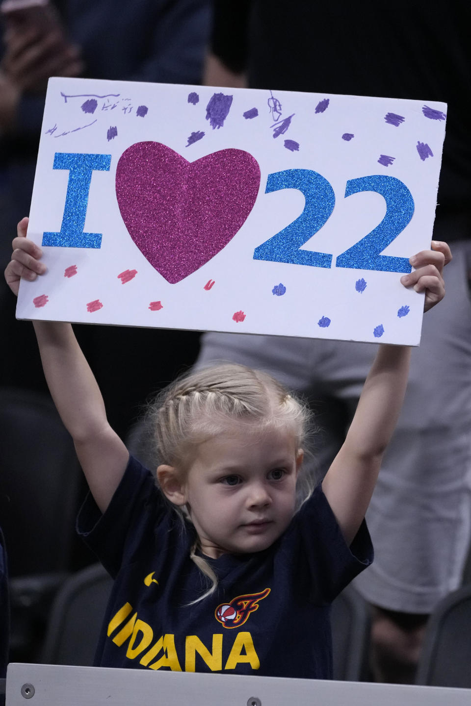 A fan watches Indiana Fever guard Caitlin Clark warm up before a WNBA basketball game against the New York Liberty, Thursday, May 16, 2024, in Indianapolis. (AP Photo/Michael Conroy)