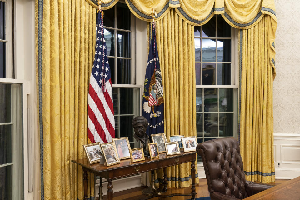 The Oval Office of the White House is newly redecorated for the first day of President Joe Biden's administration, Wednesday, Jan. 20, 2021, in Washington, including a table with family photos. (AP Photo/Alex Brandon)