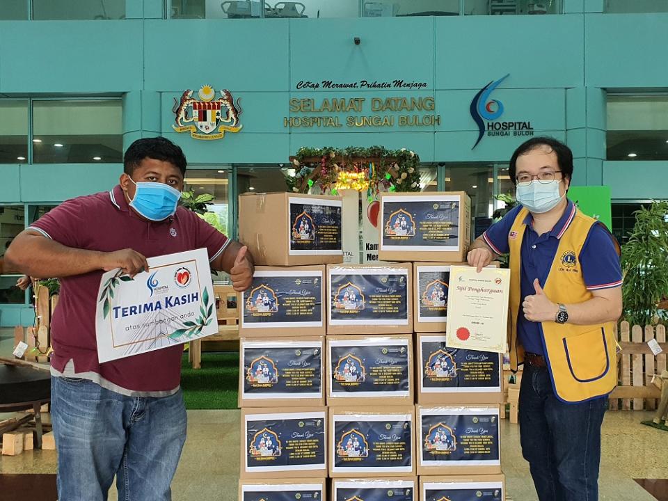 Ling (right) presenting the meals to a HSB representative last Friday, the second day of Hari Raya. — Picture courtesy of Ling Hua Bin