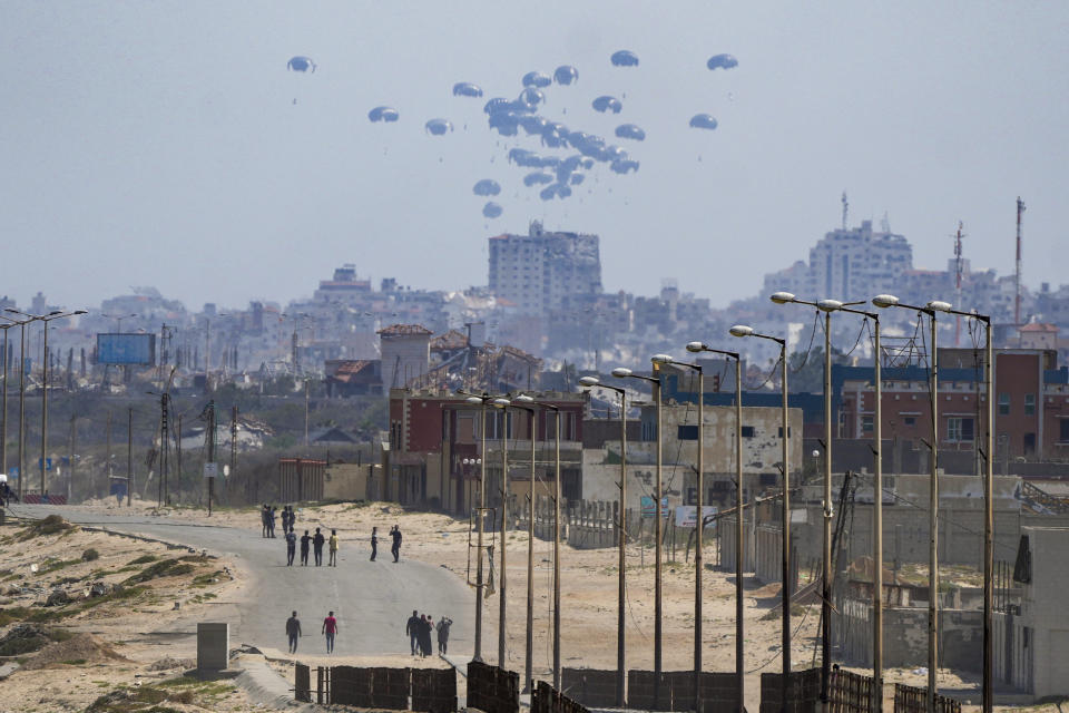 An aircraft airdrops humanitarian aid over the northern Gaza Strip, as seen from central Gaza, Tuesday, April 30, 2024. (AP Photo/Abdel Kareem Hana)