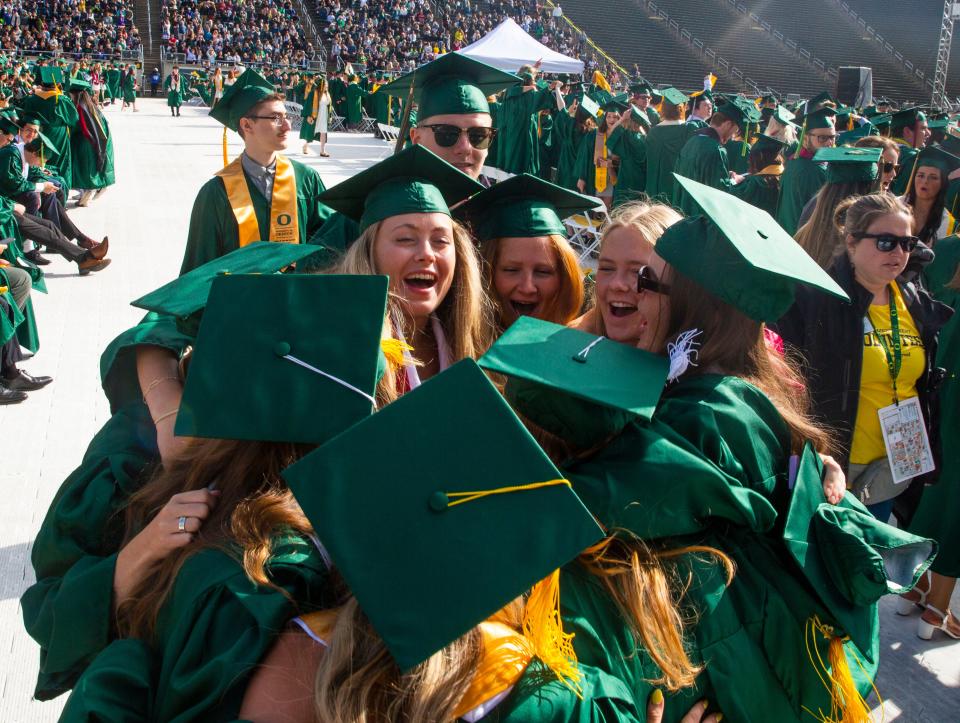 Oregon graduates celebrate as they enter Autzen Stadium for their commencement ceremony.