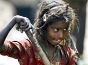 A young Indian rag picker looks for recyclable spare parts at an automobile yard on the outskirts of Jammu, India, Wednesday, March 26, 2008. (AP Photo/Channi Anand)