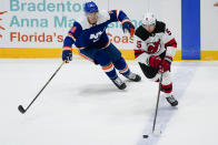 New York Islanders' Ross Johnston (32) defends against New Jersey Devils' Connor Carrick (5) during the first period of an NHL hockey game Thursday, May 6, 2021, in Uniondale, N.Y. (AP Photo/Frank Franklin II)