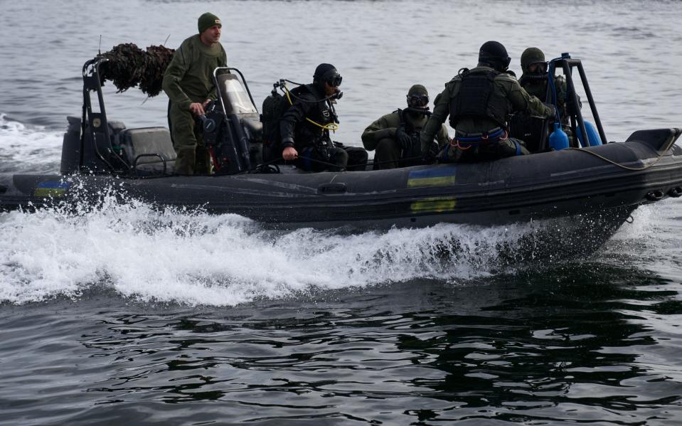 Ukrainian divers take part in a training exercise on board a dinghy