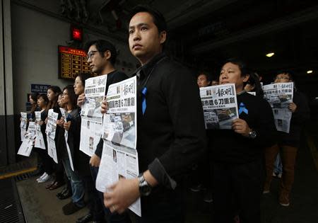 Journalists and editors from Ming Pao hold up front pages of their newspaper during a protest against violence outside their office in Hong Kong February 27, 2014, after Wednesday's attack on their former chief editor Kevin Lau. REUTERS/Bobby Yip