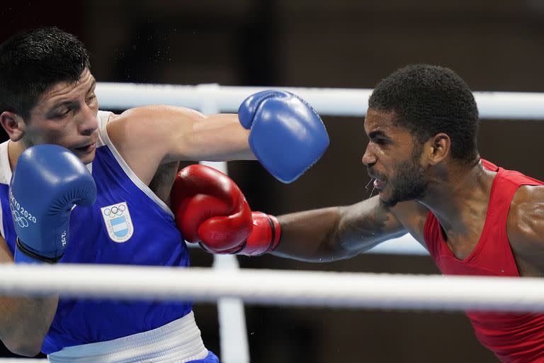 Delante Johnson, de Estados Unidos, a la derecha, recibe un puñetazo del argentino Brian Agustín Arregui durante su combate de boxeo masculino de 69 kg en peso welter
