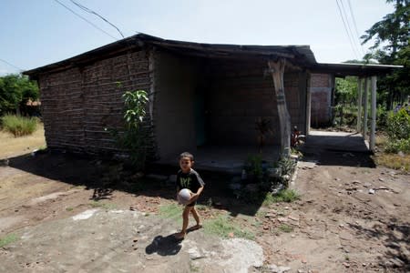 A child plays outside the house of late Honduran migrant Herrera in El Limon