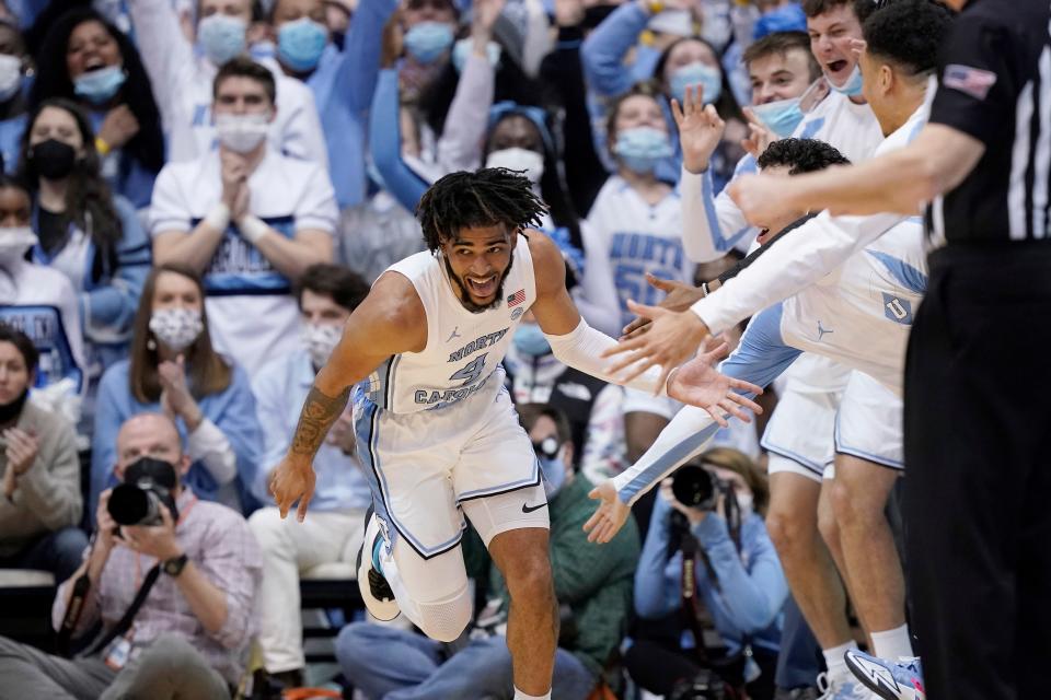 North Carolina guard RJ Davis gets congratulated by teammates on the bench after scoring against N.C. State on Saturday at the Smith Center.