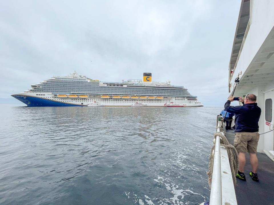 Person, die ein Foto vom Kreuzfahrtschiff Carnival Firenze macht. 