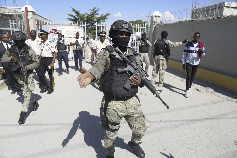 Police guard the airport in Port-au-Prince, Haiti, upon the arrival of coup leader Guy Philippe, who was deported from the U.S. on Thursday, Nov. 30, 2023. (AP Photo/Odelyn Joseph)