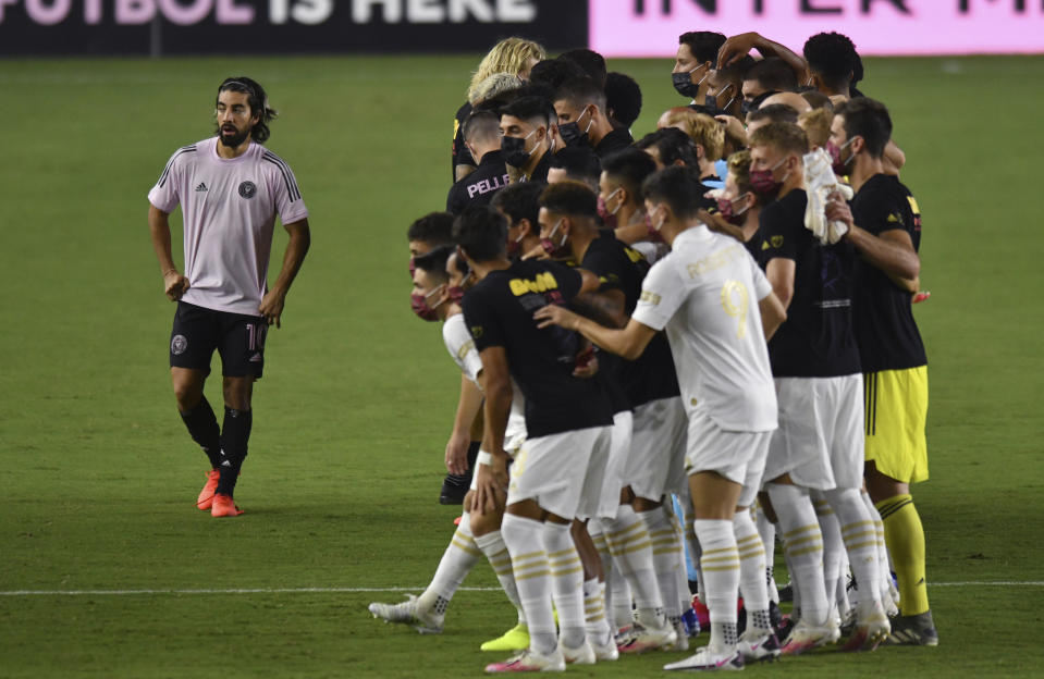 Inter Miami midfielder Rodolfo Pizarro (10) stands alongside teammates and Atlanta United players for a group photo before the MLS soccer match was called off, Wednesday, Aug. 26, 2020, in Fort Lauderdale, Fla. Major League Soccer players boycotted five games Wednesday night in a collective statement against racial injustice. The players' action came after all three NBA playoff games were called off in a protest over the police shooting of Jacob Blake in Wisconsin on Sunday night. (AP Photo/Jim Rassol)