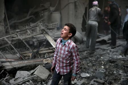 A boy reacts in a site hit by what activists said were airstrikes carried out by the Russian air force in the town of Douma, eastern Ghouta in Damascus, Syria January 10, 2016. REUTERS/Bassam Khabieh