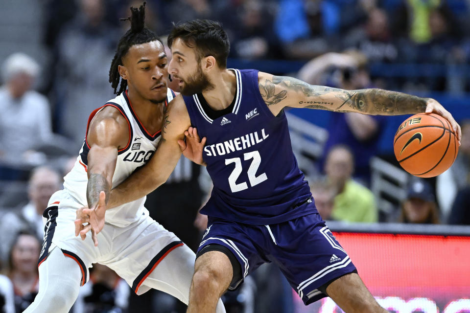 UConn's Stephon Castle, left, guards Stonehill's Pano Pavlidis in the first half of an NCAA college basketball game, Saturday, Nov. 11, 2023, in Hartford, Conn. (AP Photo/Jessica Hill)