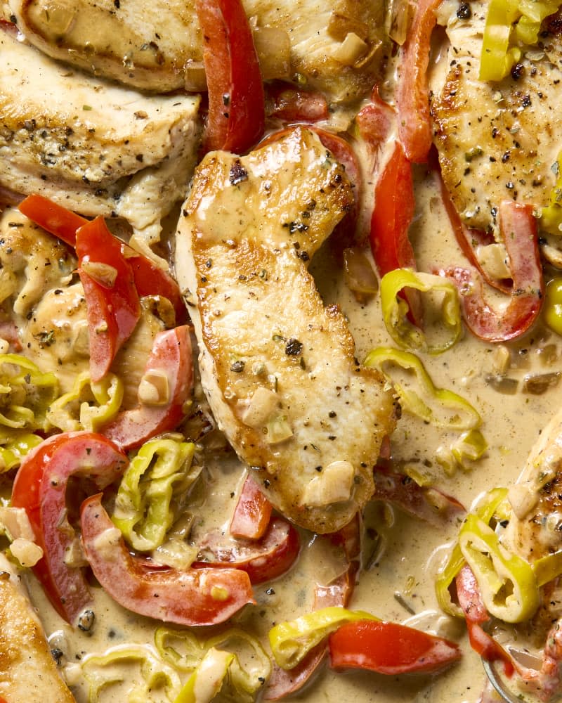 overhead shot of creamy pepperoncini chicken, with red peppers in a pan.