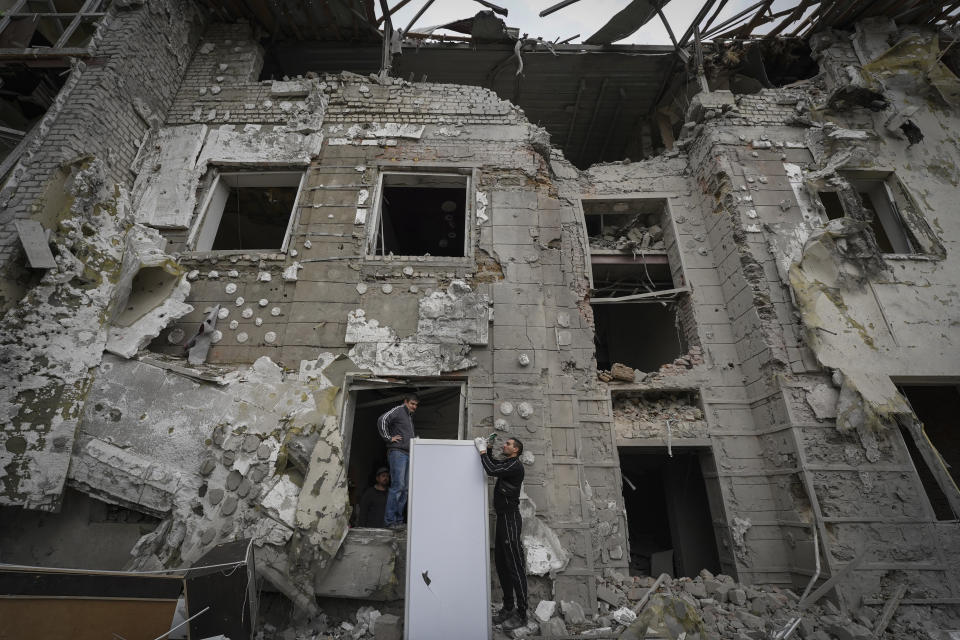 Residentes inspeccionan edificios sumamente dañados después del más reciente ataque de cohetes rusos, el lunes 12 de septiembre de 2022, en el centro de Járkiv, Ucrania. (AP Foto/Andrii Marienko)
