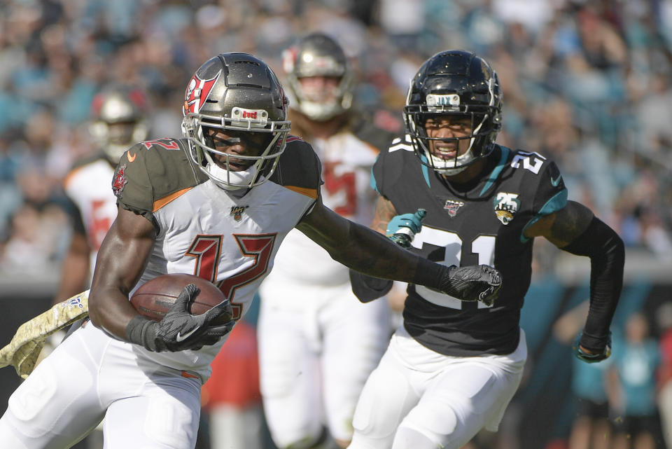 Tampa Bay Buccaneers wide receiver Chris Godwin, left, runs after a reception past Jacksonville Jaguars cornerback A.J. Bouye (21) during the first half of an NFL football game, Sunday, Dec. 1, 2019, in Jacksonville, Fla. (AP Photo/Phelan M. Ebenhack)