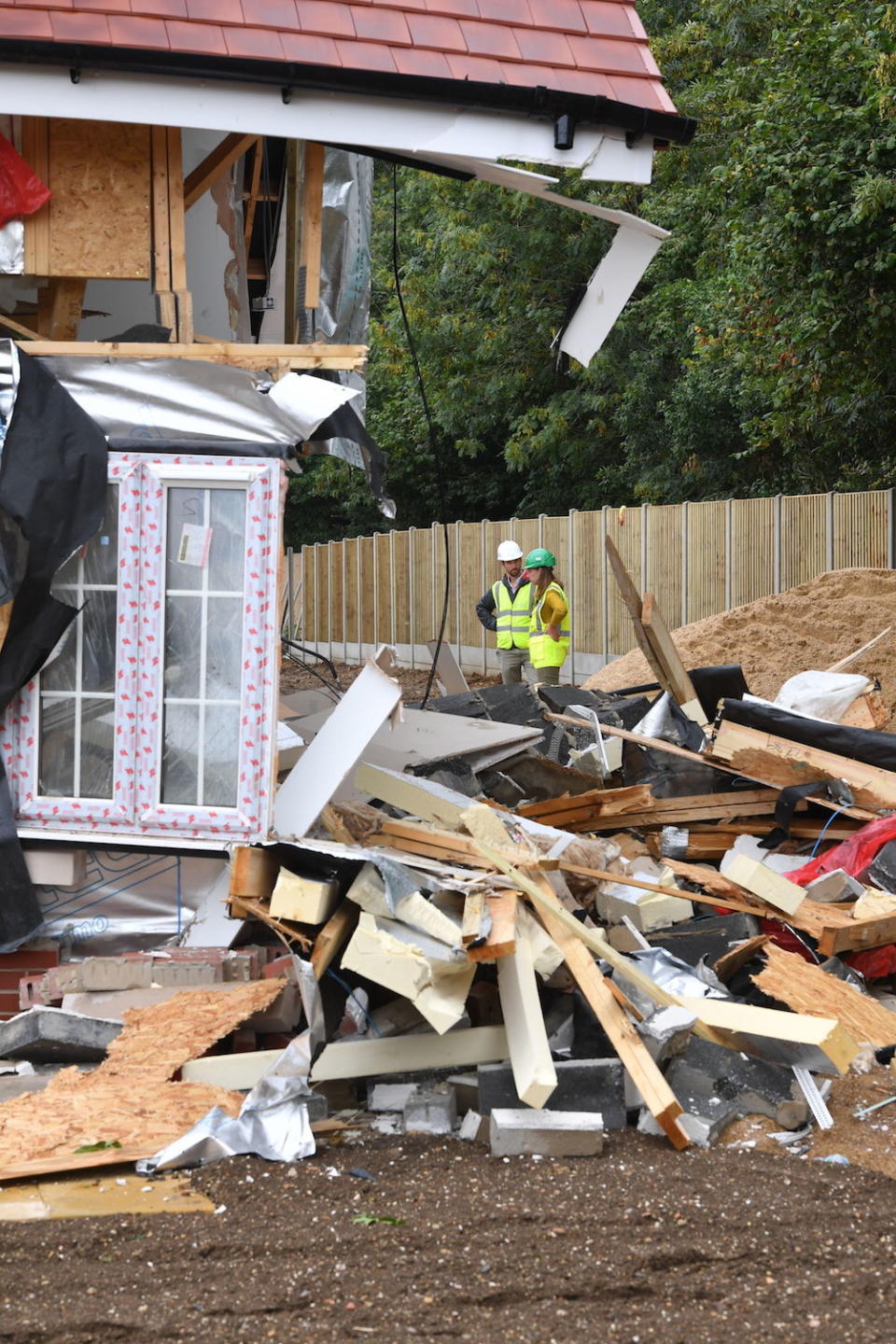People inspect damaged properties in a row of newly-built retirement homes in Ermine Street in Buntingford, Hertfordshire (Picture: PA)