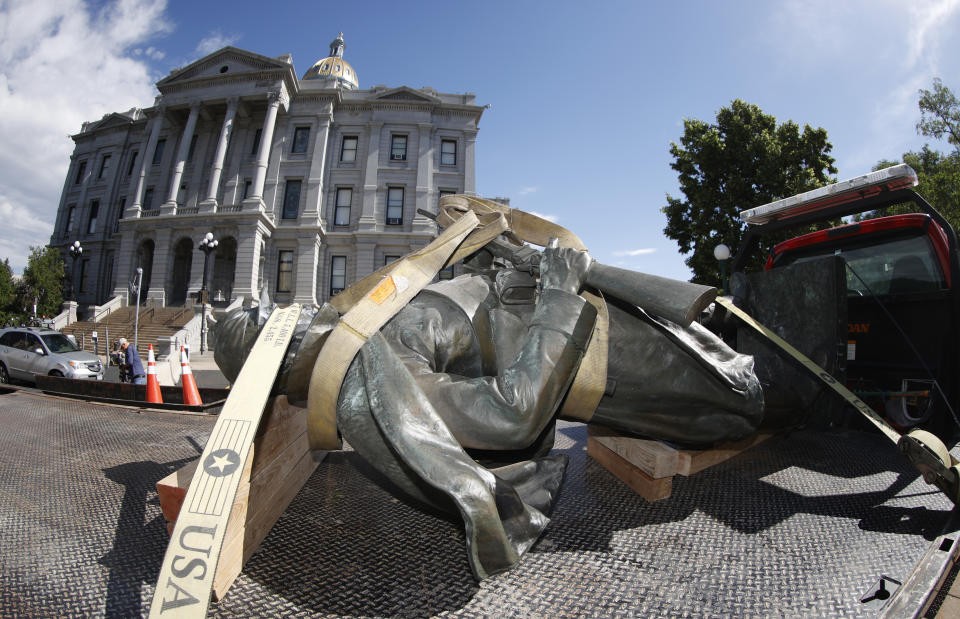 The Civil War Monument statue is strapped on the back of a flatbed tow truck after it was toppled from its pedestal in front of the State Capitol Thursday, June 25, 2020, in Denver. The monument, which portrays a Union Army soldier and was erected in 1909, was targeted during demonstrations over the death of George Floyd before the statue was pulled down overnight by four individuals. (AP Photo/David Zalubowski)