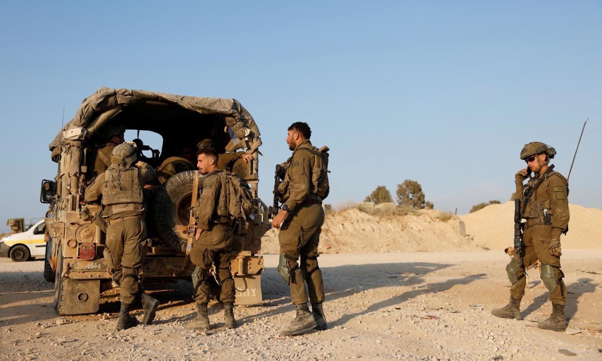 <span>Israeli soldiers at the country’s Gaza border. The IDF said two brigades would stay in the northern half of Gaza and at the Wadi Gaza corridor.</span><span>Photograph: Amir Cohen/Reuters</span>