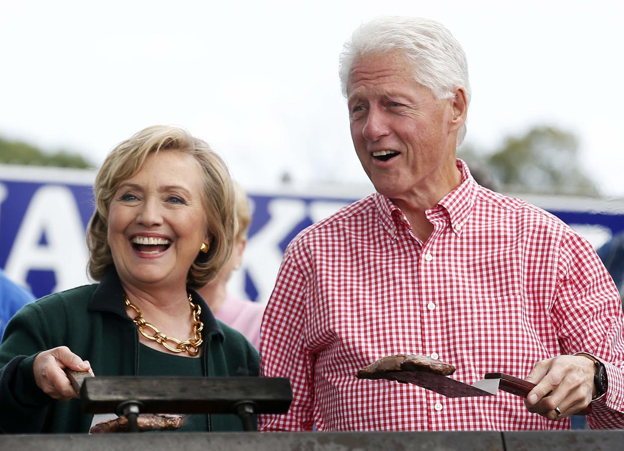 Former U.S. Secretary of State Hillary Clinton and her husband, former U.S. President Bill Clinton, hold up some steaks at the 37th Harkin Steak Fry in Indianola, Iowa, on Sept. 14, 2014. (REUTERS/Jim Young)