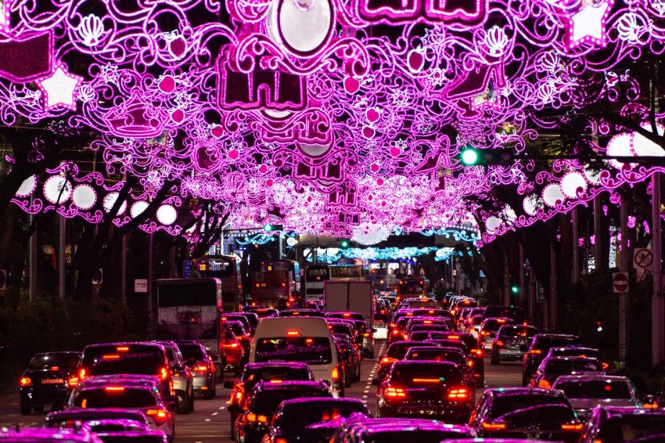 heavy traffic under illuminated arch on orchard street in singapore