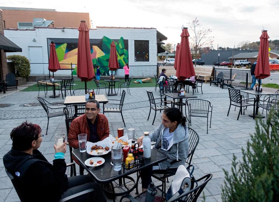 Chandni Malhotra, Shikhin and Meghna Malhotra dine on the patio at Crosstown Pub & Grill on Thursday, March 16, 2023, in Cary, N.C.