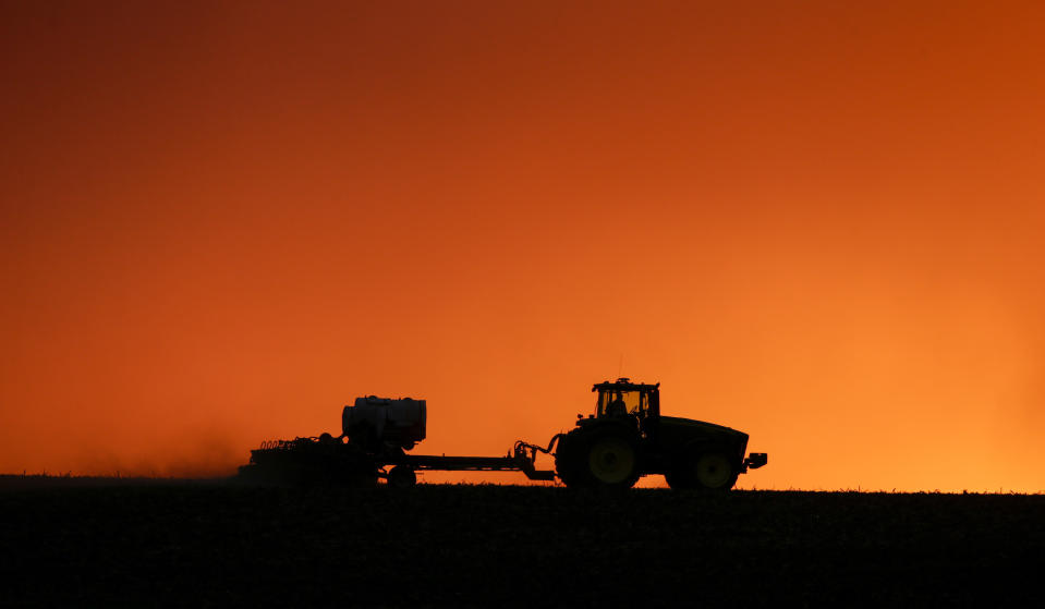 FILE - In this April 20, 2020, file photo, a farmer is silhouetted by the setting sun as a field is planted near Walford, Iowa. Thanks to the government paying nearly 40% of their income, U.S. farmers are expected to end 2020 with higher profit than 2019 and the best net income in seven years, the Department of Agriculture said in its latest farm income forecast. Farmers faced challenges throughout 2020 that included the impact of trade disputes; low prices that drove down cash receipts and weather difficulties. (Jim Slosiarek/The Gazette via AP, File)