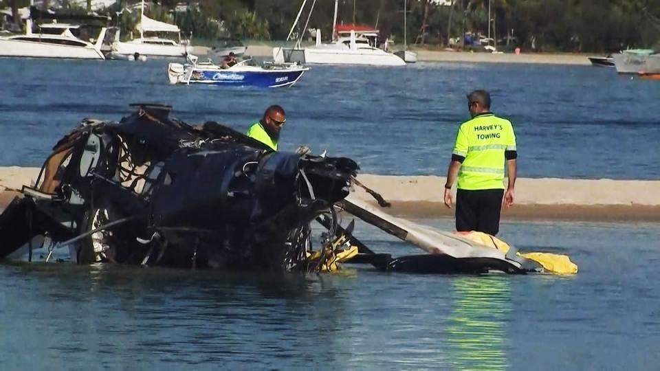 Airport workers prepare to remove a crashed helicopter that collided with another helicopter on the Gold Coast (ABC/AFP via Getty Images)