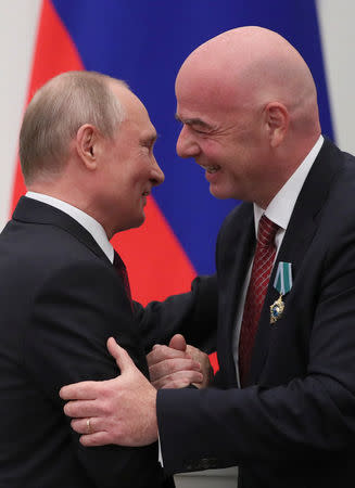 Russian President Vladimir Putin (L) embraces FIFA President Gianni Infantino after decorating him with the Order of Friendship during an awarding ceremony at the Kremlin in Moscow, Russia May 23, 2019. REUTERS/Evgenia Novozhenina