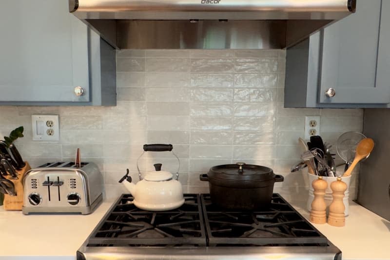 Neutral backsplash behind gas range in newly renovated kitchen.