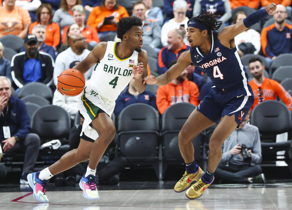 Baylor guard LJ Cryer, left, drives against Virginia guard Armaan Franklin during the first half of an NCAA college basketball game Friday, Nov. 18, 2022, in Las Vegas. (AP Photo/Chase Stevens)