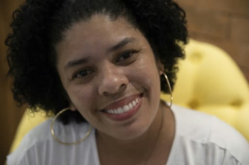 Ana Claudia, 37, smiles as she poses for pictures. She was helped by an NGO of volunteer dentists that provides abuse victims with dental implants under the condition they leave their violent partners