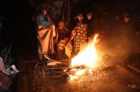 People warm themselves around a bonfire in the rubble in Kahramanmaras, Turkey, after a 7.8-magnitude earthquake struck the country’s southeast (AFP via Getty Images)