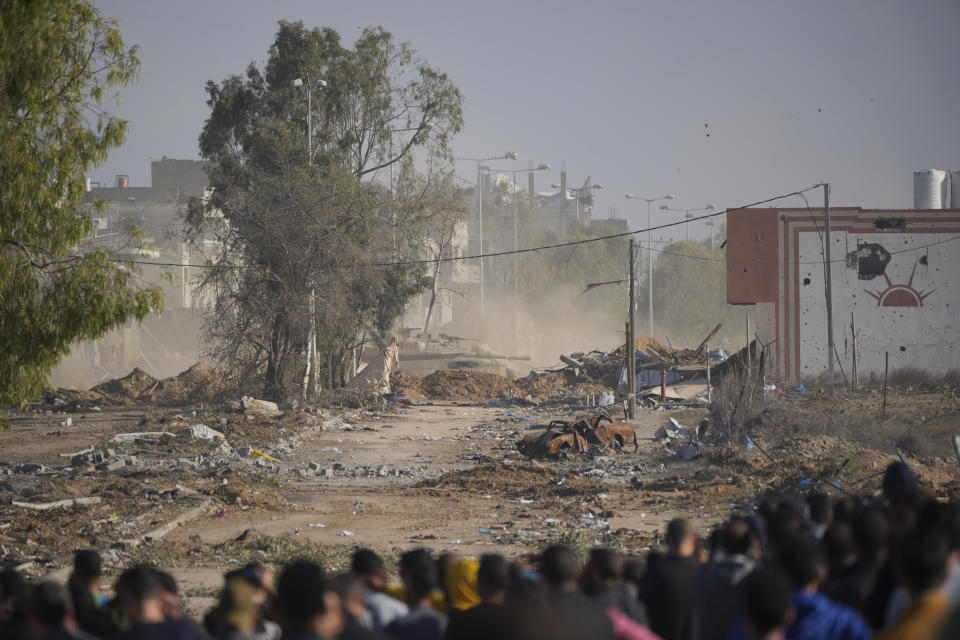 Palestinians try to cross back into northern Gaza as an Israeli tank blocked the Salah al-Din road in the central Gaza Strip on Friday, Nov. 24, 2023, as the temporary ceasefire went into effect. (AP Photo/Hatem Moussa)