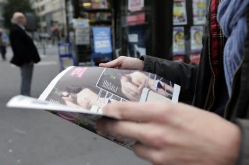 A man holds a copy of the celebrity magazine Closer, which published topless pictures of Prince William's wife Catherine, Duchess of Cambridge, taken while the pair were on holiday in France