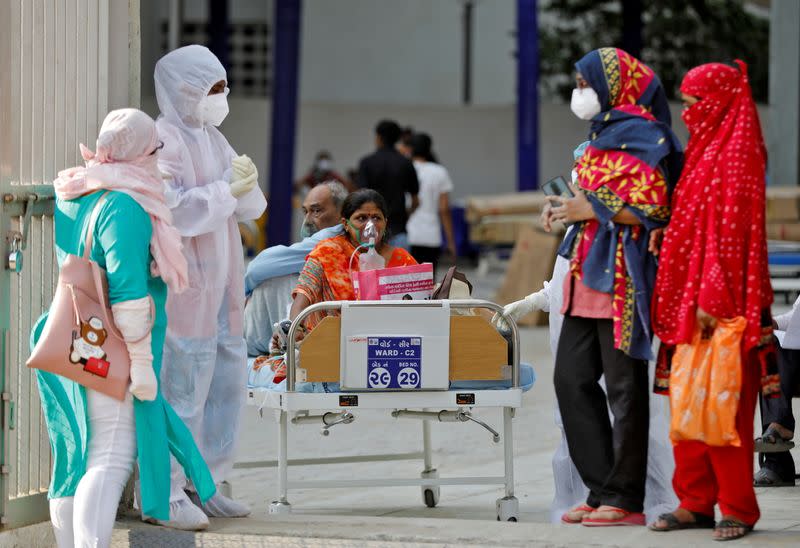 Patients sit on bed waiting to be shifted to a hospital, amidst the spread of the coronavirus disease (COVID-19) in Ahmedabad