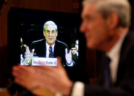 FILE PHOTO: Robert Mueller (R) , serving as Federal Bureau of Investigation director, is seen on a TV monitor at the U.S. Senate Judiciary Committee at an oversight hearing about the FBI on Capitol Hill in Washington, June 19, 2013. REUTERS/Larry Downing/File Photo