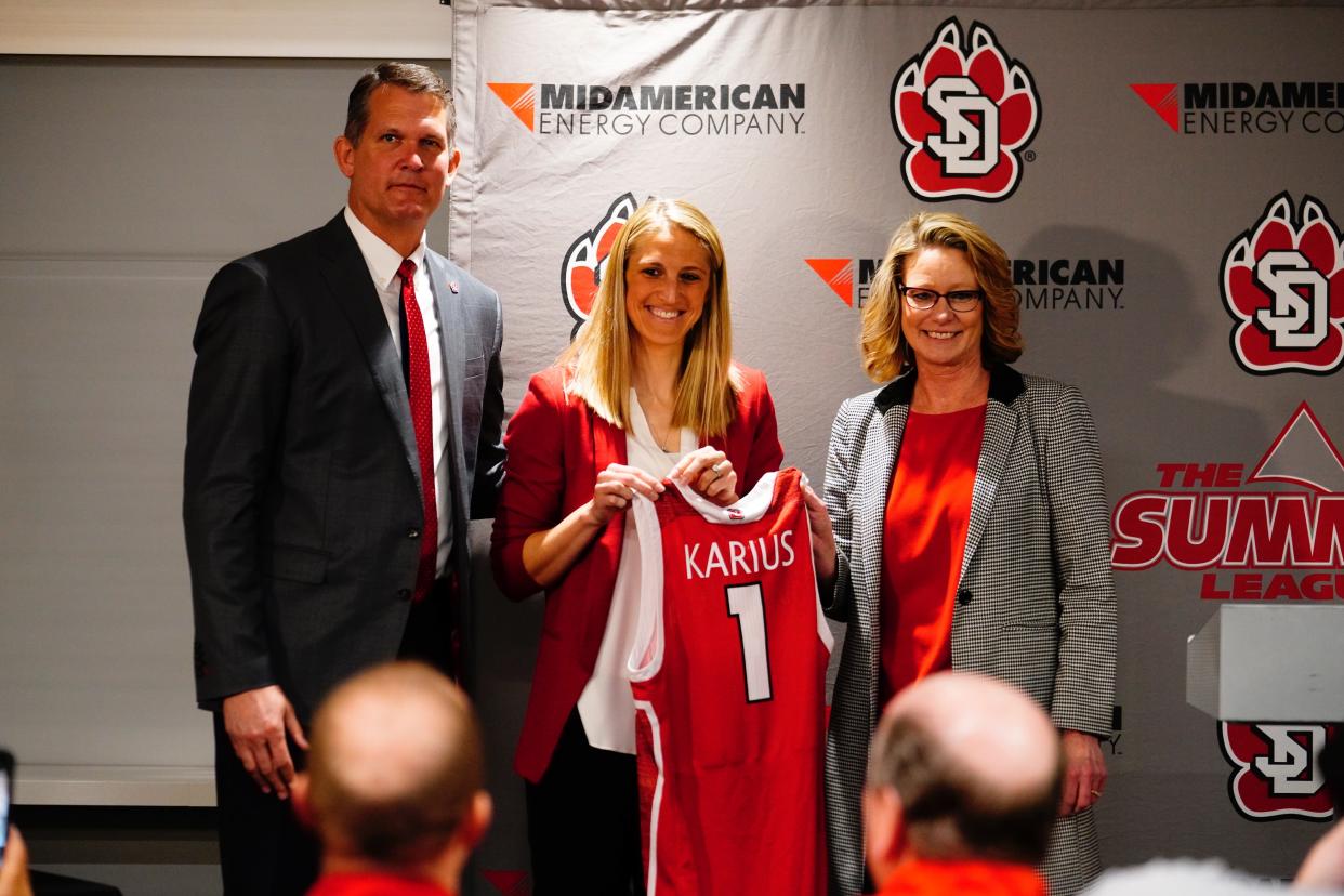 University of South Dakota women's basketball coach Kayla Karius is introduced by athletic director David Herbster and President Sheila Gestring on April 11, 2022, in Vermillion.