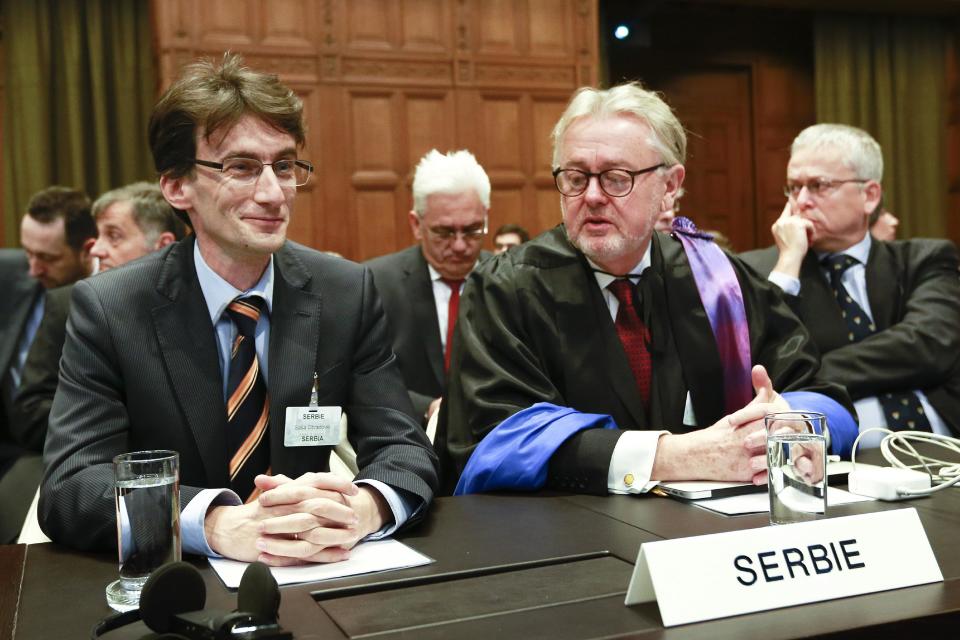 Members of the Serbian delegation, First Counsellor Sasa Obradovic, left, William Schabas, center and Andreas Zimmermann, right, await the start of public hearings at the International Court of Justice (ICJ) in The Hague, Netherlands, Monday, March 3, 2014. Croatia is accusing Serbia of genocide during fighting in the early 1990's as the former Yugoslavia shattered in spasms of ethnic violence, in a case at the United Nations' highest court that highlights lingering animosity in the region. Croatia is asking the ICJ to declare that Serbia breached the 1948 Genocide Convention when forces from the former Federal Republic of Yugoslavia attempted to drive Croats out of large swaths of the country after Zagreb declared independence in 1991. (AP Photo/Jiri Buller)
