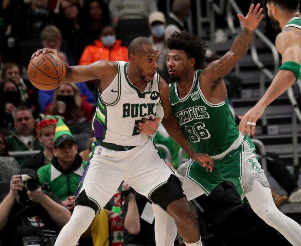 Bucks forward Khris Middleton looks to drive as Celtics guard Marcus Smart defends.