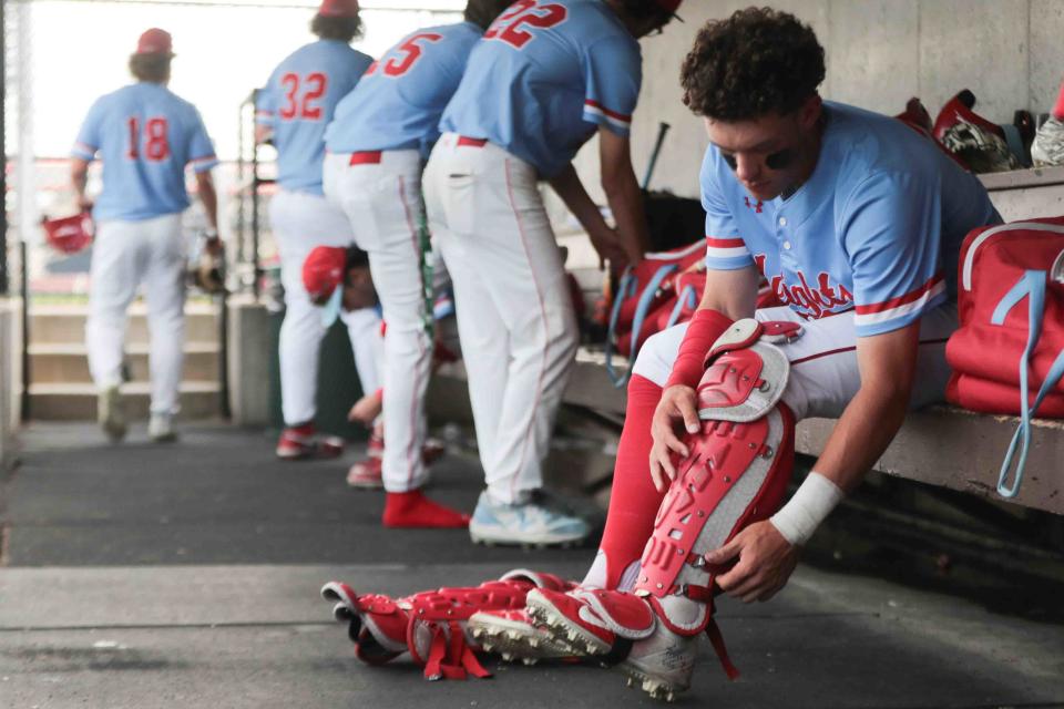 Shawnee Heights junior Deacon Pomeroy (24) begins removing his catchers padding following the conclusion of their game against Washburn Rural on April 30 at Bettis Family Sports Complex.