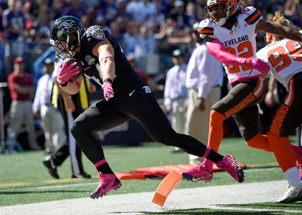 Baltimore Ravens fullback Kyle Juszczyk, left, scores a touchdown in front of Cleveland Browns cornerback Tramon Williams (22) and outside linebacker Paul Kruger (99) on Oct. 11, 2015, in Baltimore.