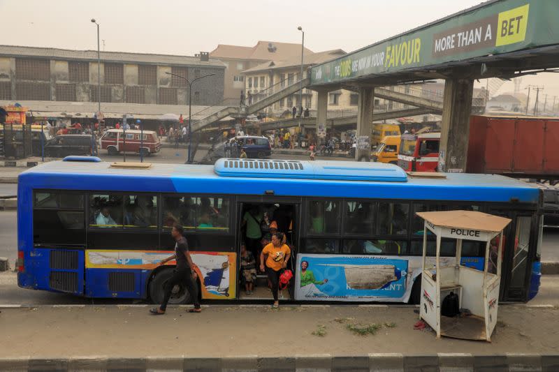 Passengers alight from a bus at Barracks bus-stop in Lagos